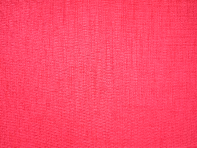 Close view of vivid raspberry-pink flat weave with a fine crosshatched texture