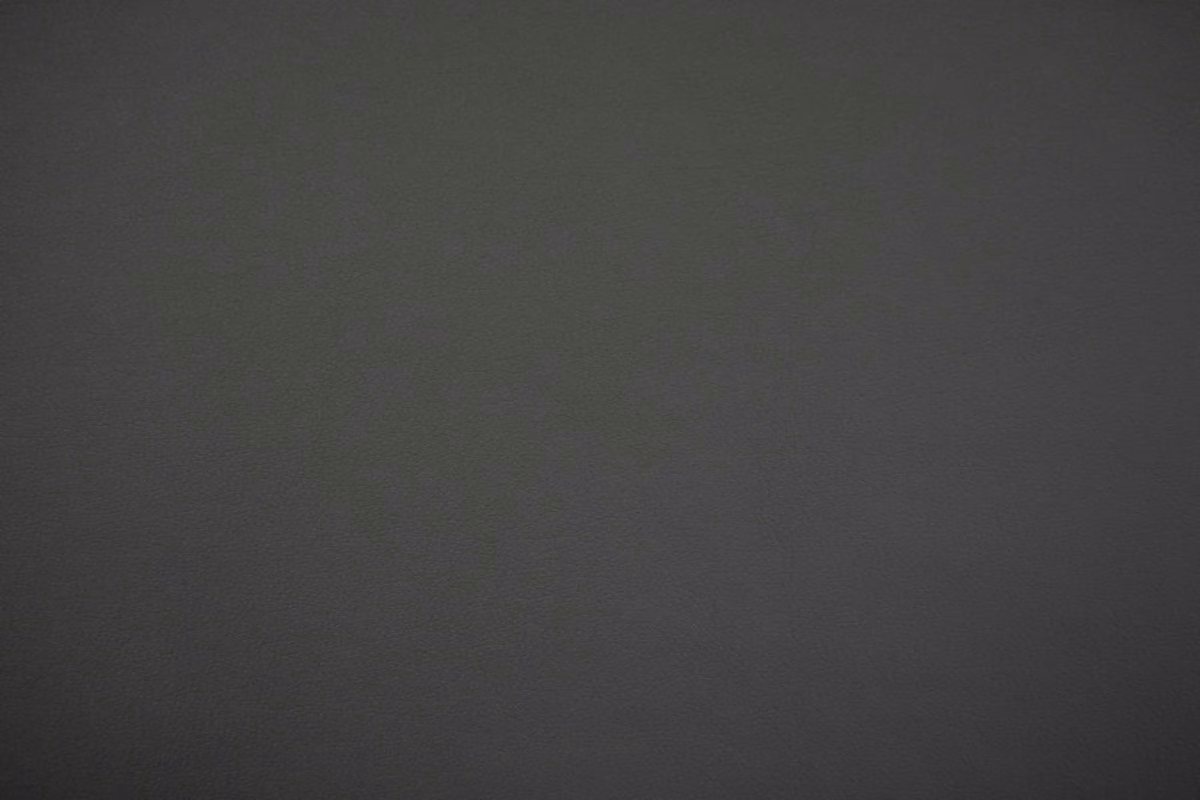 Deep charcoal-black faux leather swatch with subtle grain and low sheen