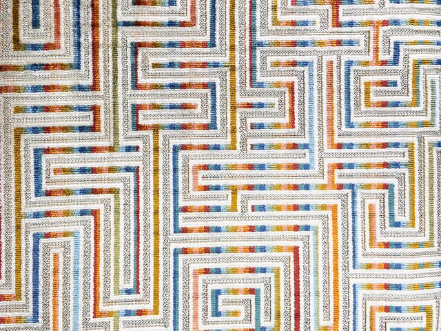 Ivory velvet with blue, rust and ochre maze lines in a textured close-up