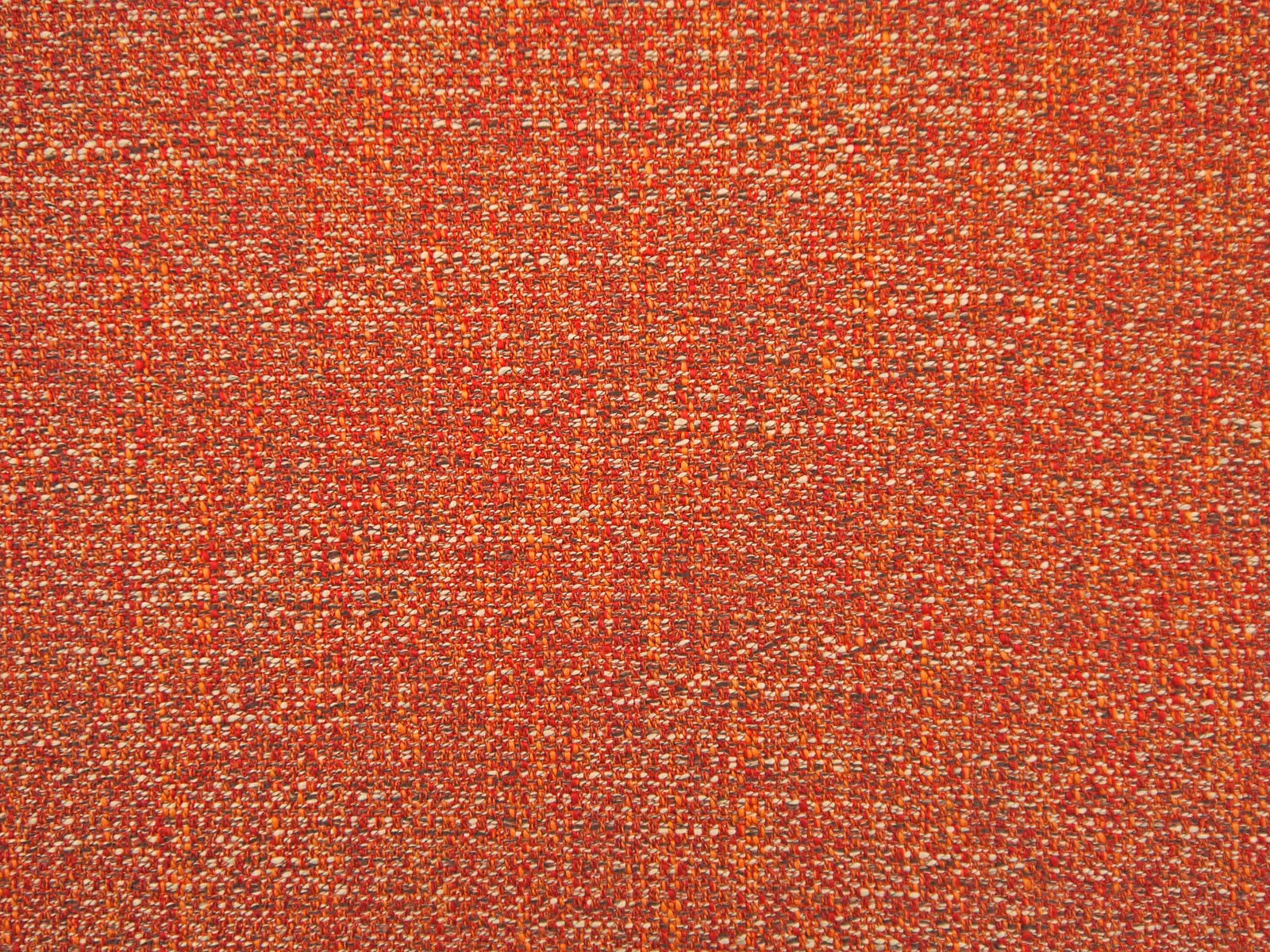Close-up of deep rust-red chenille with orange, ochre and pale flecked texture