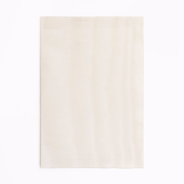 Pale ivory-blush curtain fabric with subtle vertical tonal striations