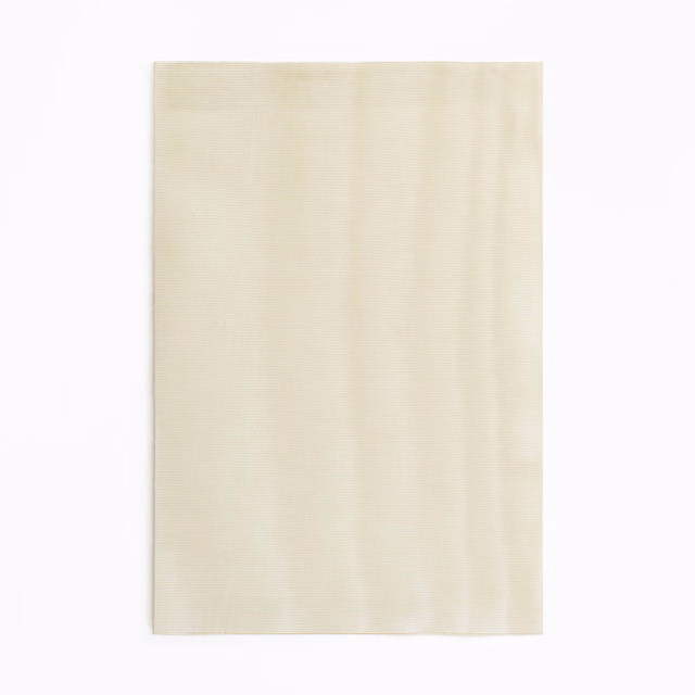 Warm ivory curtain cloth with delicate vertical striations and a softly uneven sheen