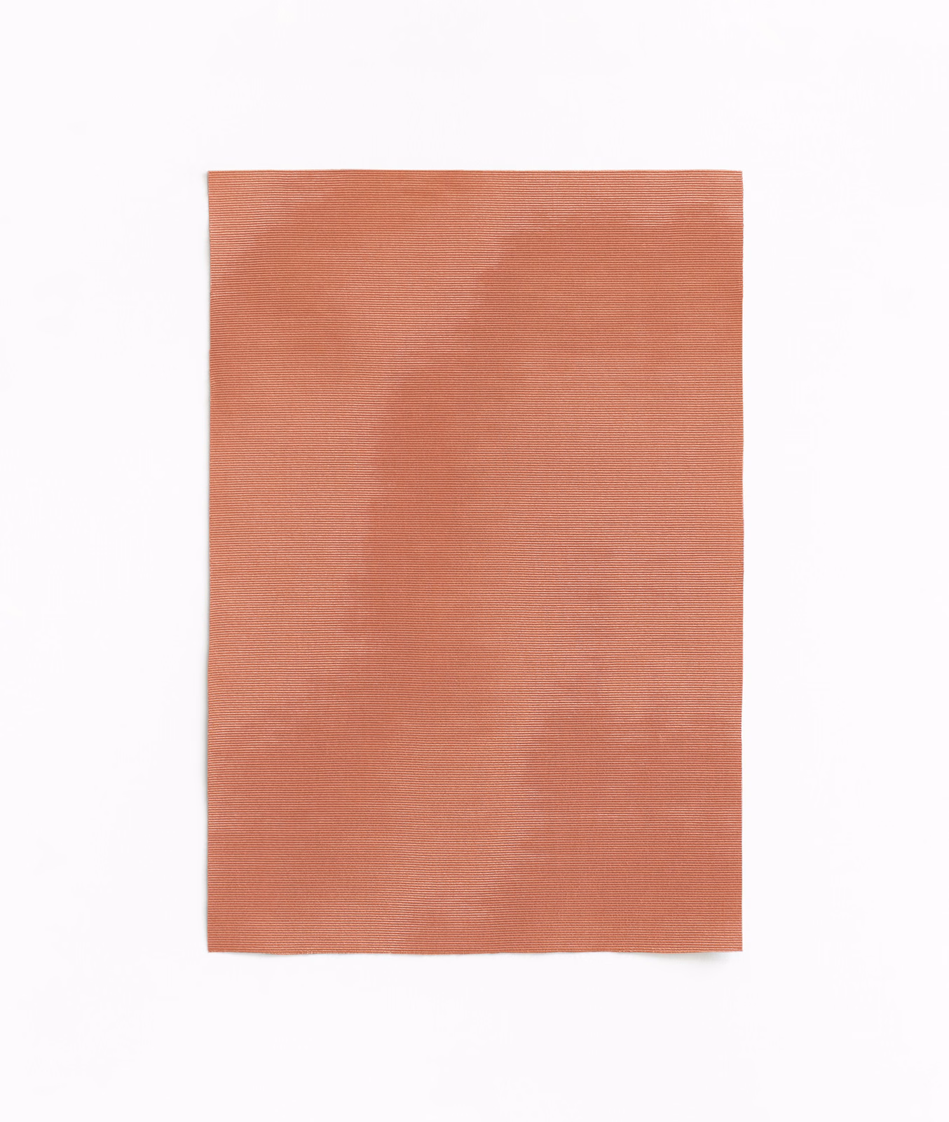 Dusty salmon textile with a softly brushed, clouded surface and fine weave