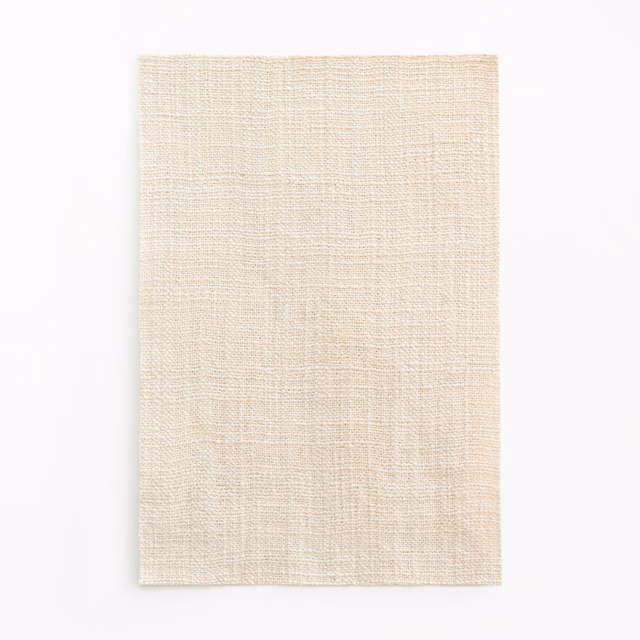 Warm ivory curtain fabric showing a fine crosshatched woven texture