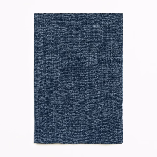 Deep indigo curtain fabric with a fine, tightly crosshatched woven texture