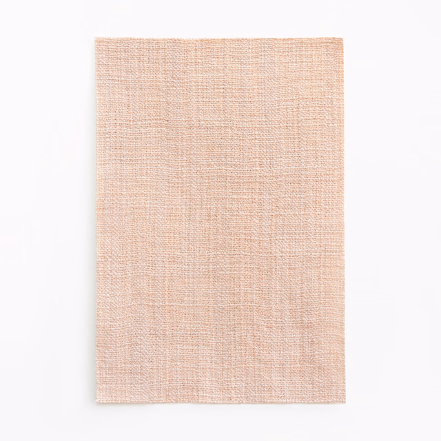 Pale blush-pink curtain fabric with a fine crosshatched woven surface