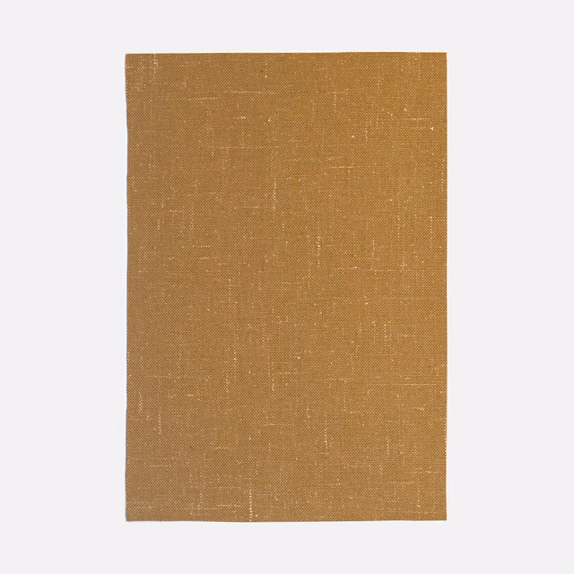 Warm curry ochre plain-weave textile with subtle slub lines and pale flecks