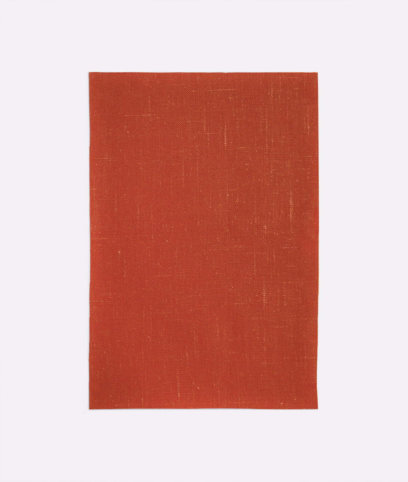 Burnt terracotta red woven curtain fabric with a fine, softly crosshatched texture