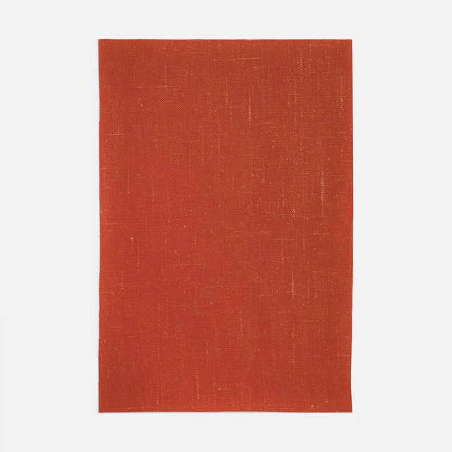 Burnt terracotta red woven curtain fabric with a fine, softly crosshatched texture