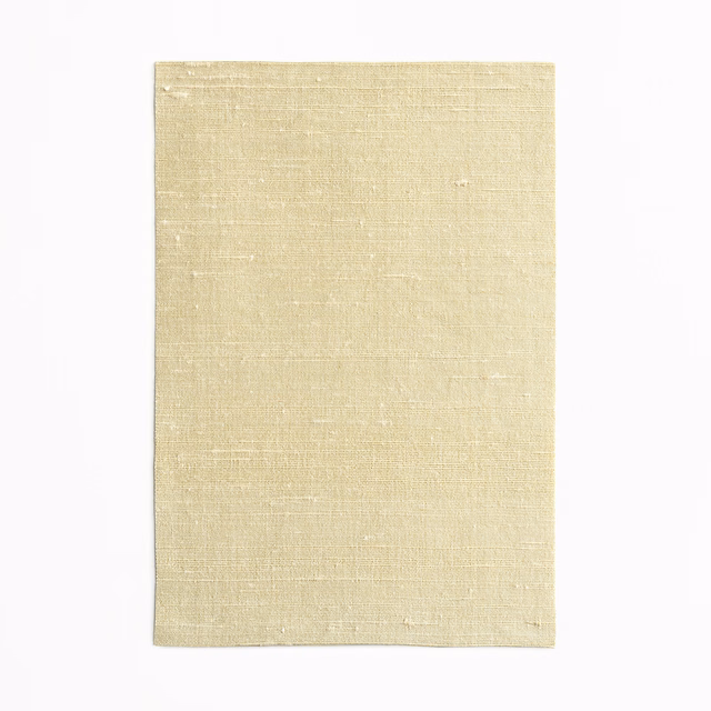 Pale amber fabric swatch with irregular slubbed weave and subtle horizontal texture