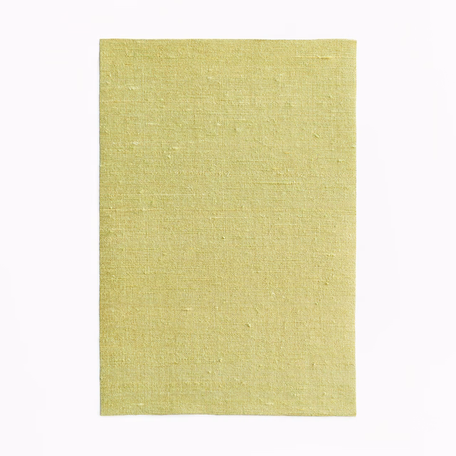 Pale chartreuse-green curtain fabric with subtle slubbed woven texture