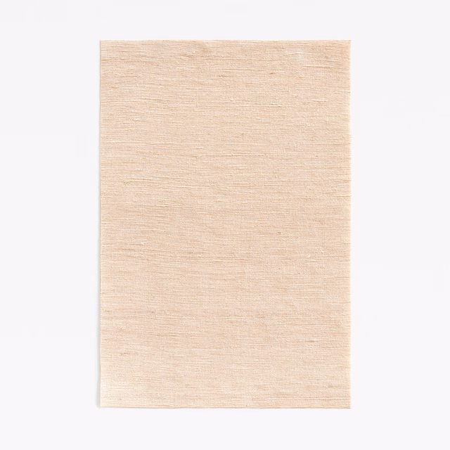 Warm nude beige fabric with fine horizontal slubbing and softly luminous texture