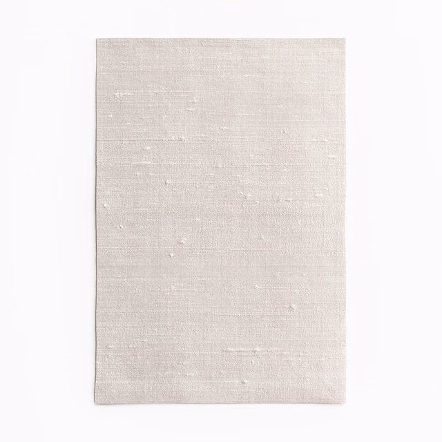 Pale pearl textile swatch with fine horizontal grain and tiny irregular flecks