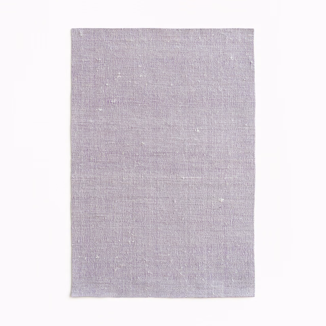 Pale greyed-lilac curtain fabric swatch with fine woven texture and subtle flecks