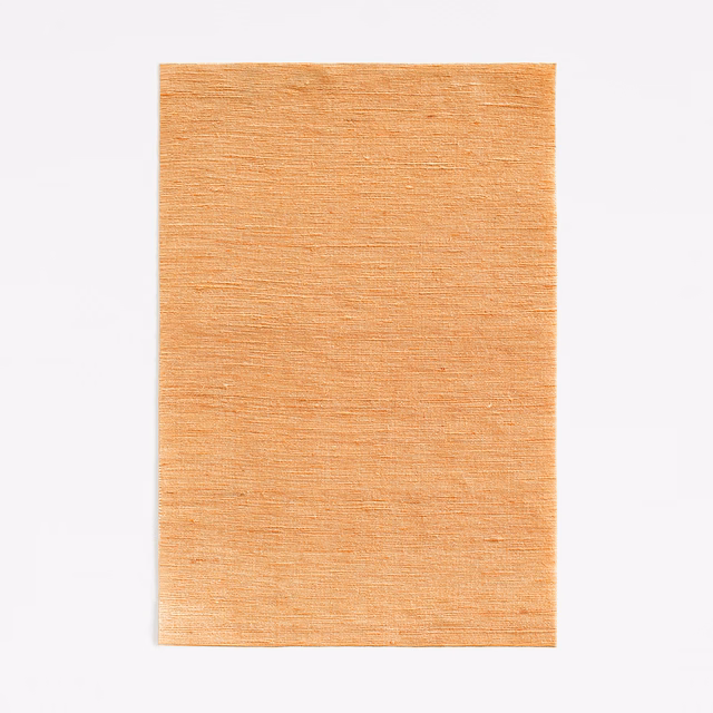 Warm copper-orange curtain fabric with fine horizontal slub texture