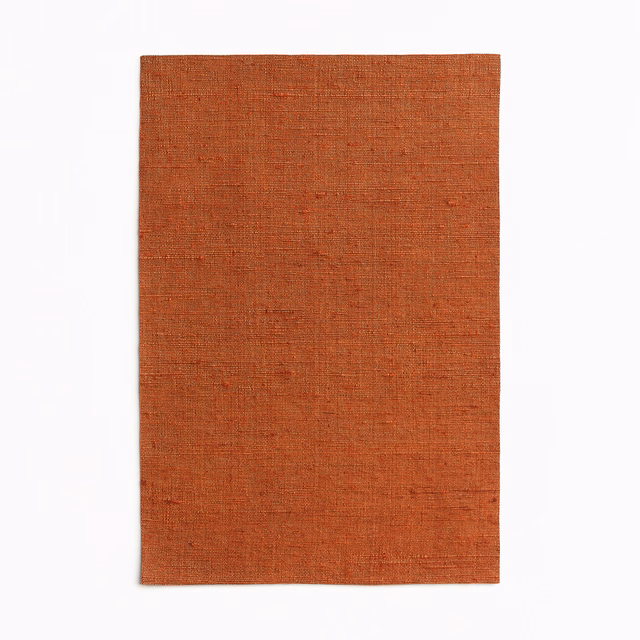 Burnt rust-orange curtain fabric with a fine, subtly irregular plain weave