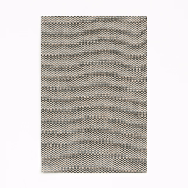 Silvery grey curtain fabric with a dense charcoal-and-cream micro-weave