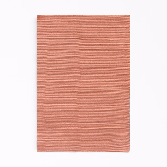 Dusty coral-terracotta curtain fabric with fine horizontal ribbed texture