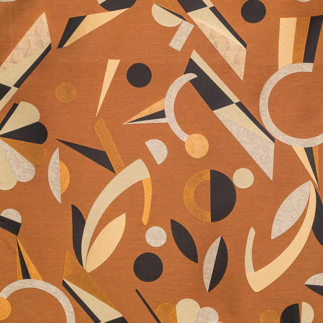 Copper-toned textile with cream arcs, black shapes, ochre lines and rounded motifs