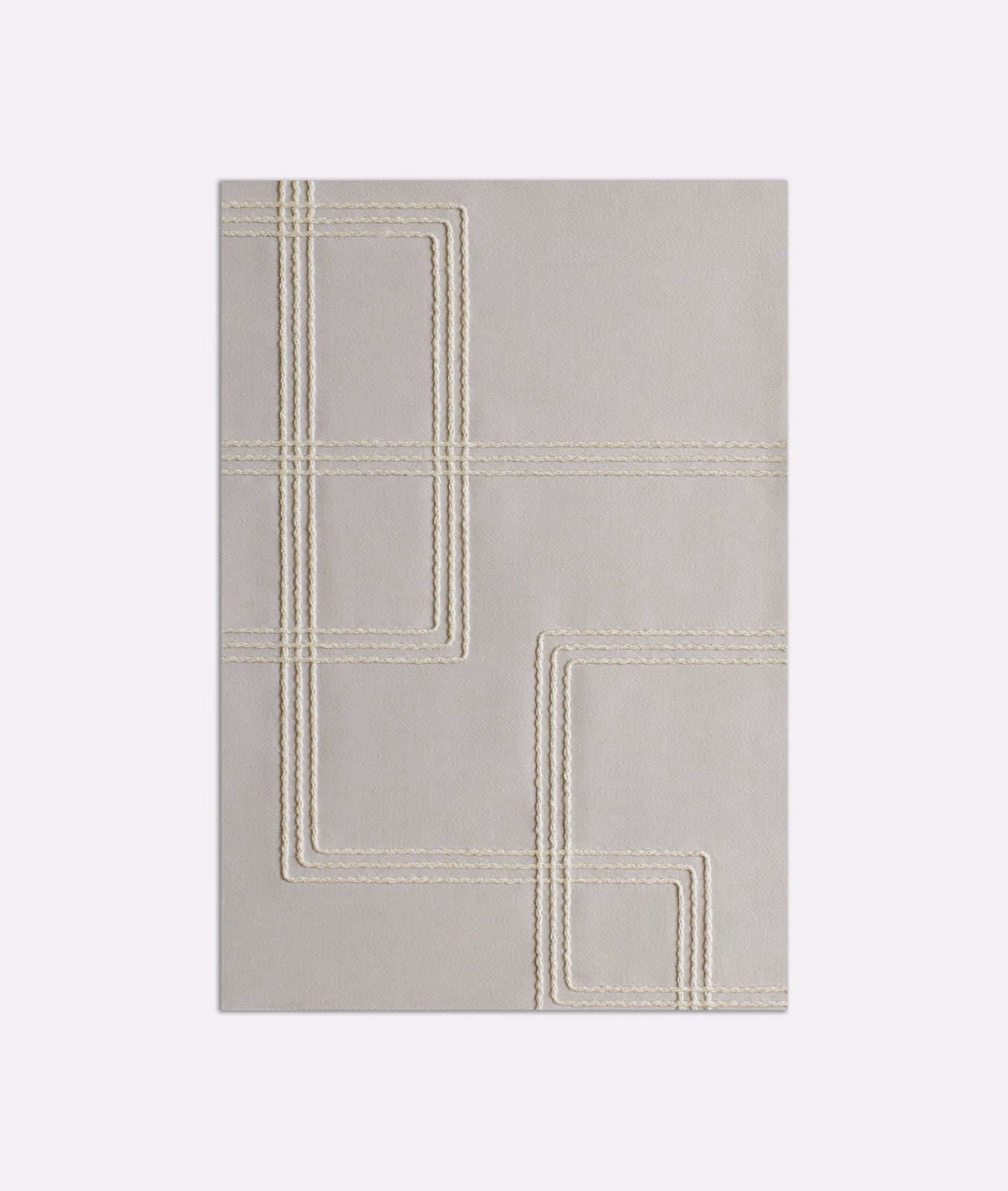 Pale grey fabric with ivory stitched geometric lines forming nested angular panels