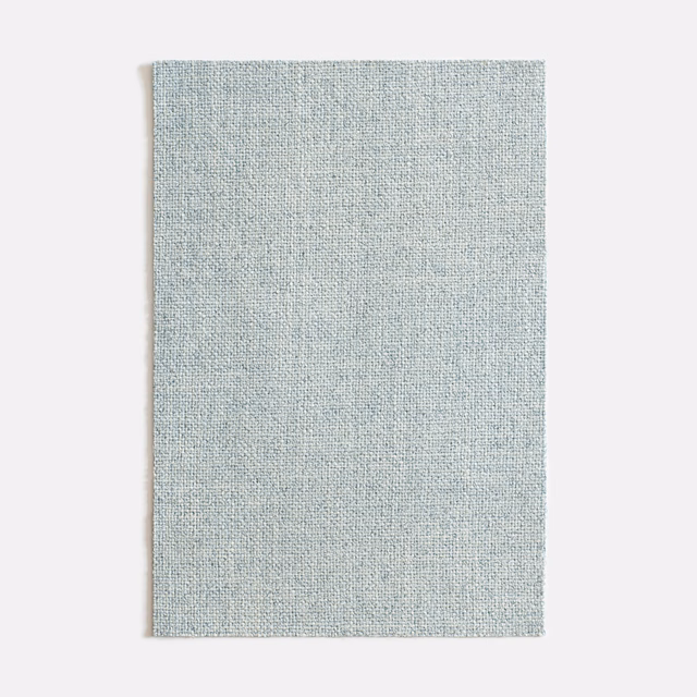 Pale aqua-blue woven fabric swatch with fine mottled texture and softly varied surface