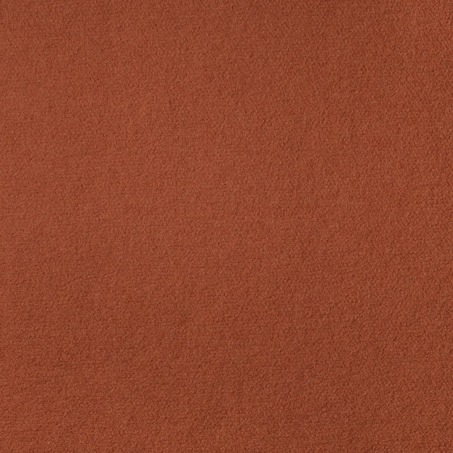 Close-up of warm burnt-terracotta Zucca fabric with a finely mottled matte weave