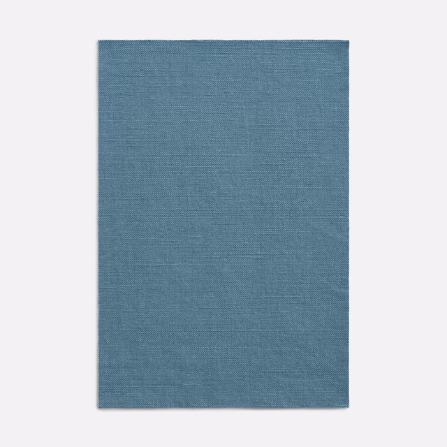 Muted denim-blue curtain fabric with a fine, even horizontal woven texture