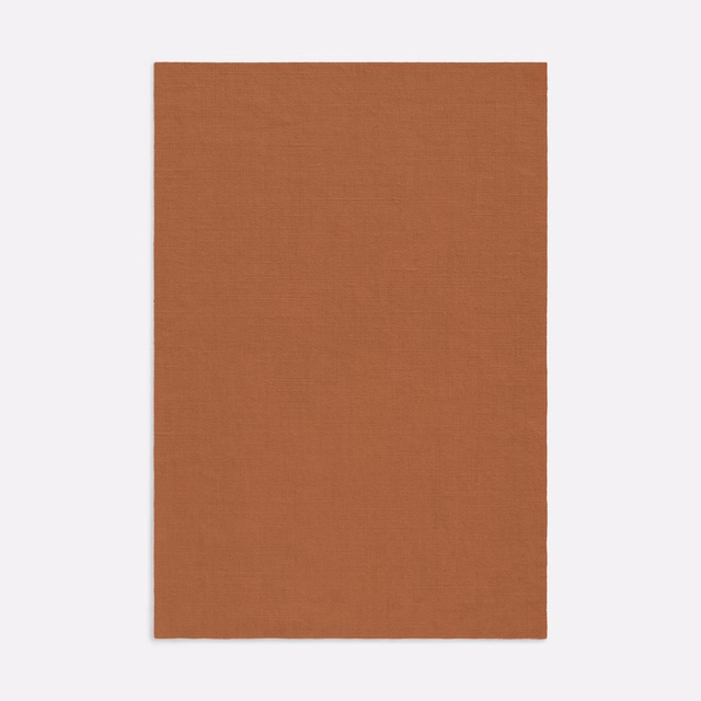 Warm rust-terracotta Salicornia swatch showing a fine, subtly slubbed plain weave