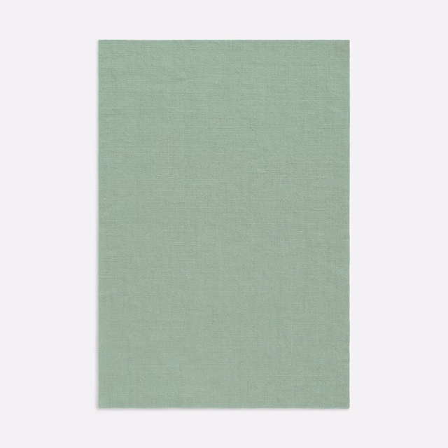 Pale sage-green Dedar curtain fabric with a fine, softly textured plain weave