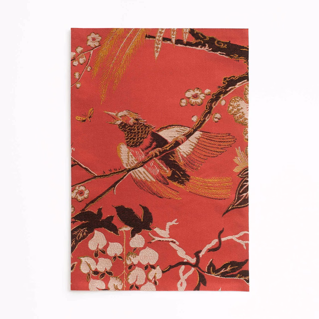 Lacquer-red jacquard with a soaring crane, blossom clusters and black branches