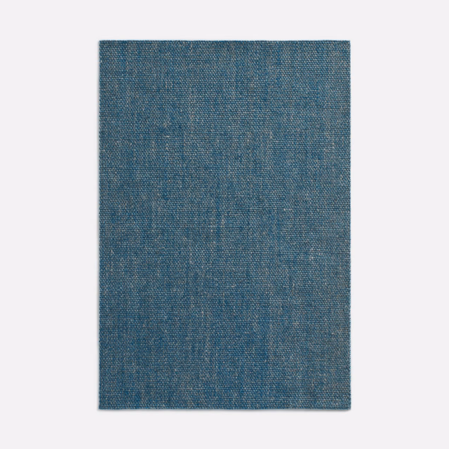Muted denim-blue woven curtain fabric with fine mottled texture