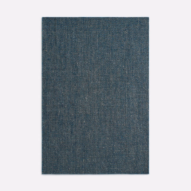 Deep indigo textile with a fine mottled woven surface and subtle blue-grey variation