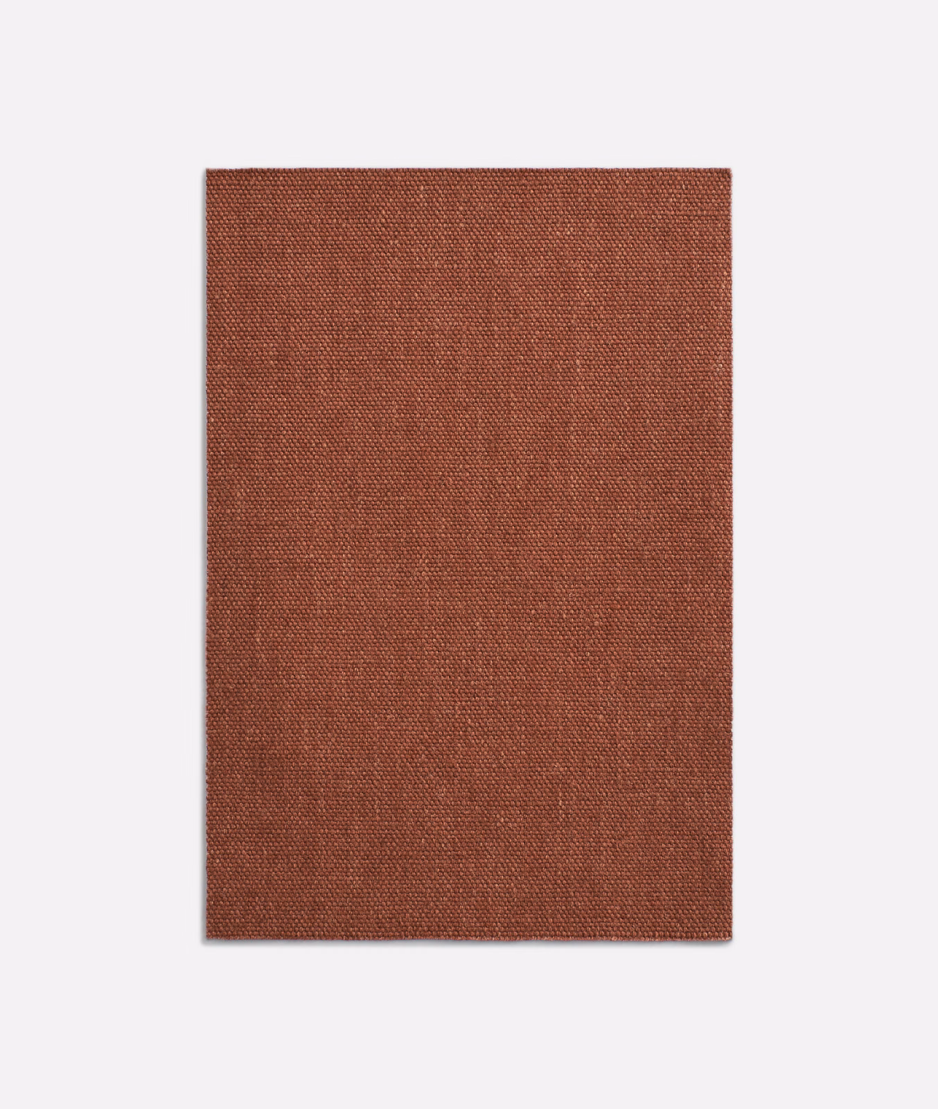 Close-up of rust terracotta fabric with a fine, subtly mottled plain weave