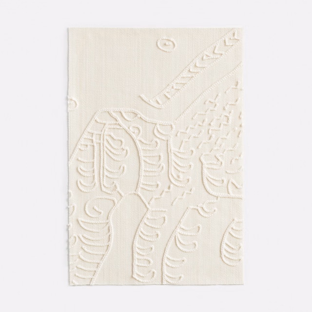 Warm ivory woven swatch with raised scrolling botanical embroidery and small loop details