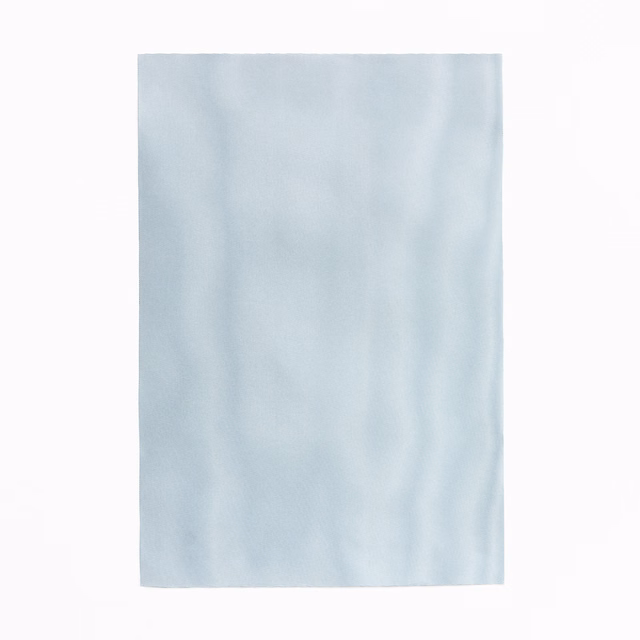 Pale icy blue curtain fabric with soft vertical tonal shading and a smooth surface