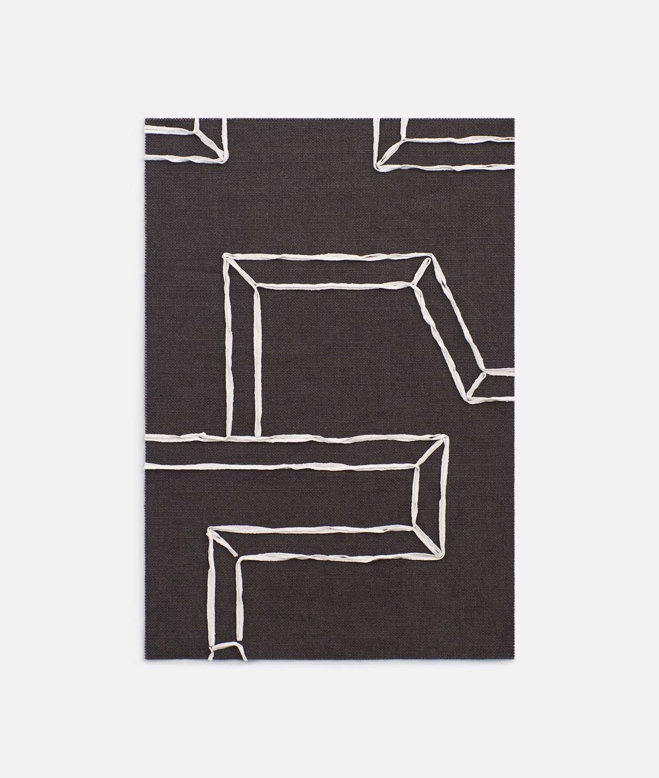 Charcoal-black fabric with irregular ivory geometric outlines in a bold architectural pattern