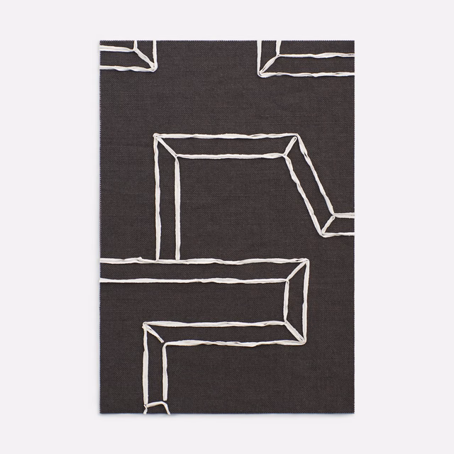 Charcoal-black fabric with irregular ivory geometric outlines in a bold architectural pattern