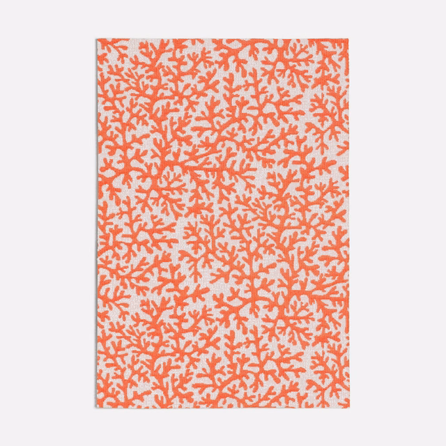Warm coral branching coral motif scattered across a pale cream fabric ground