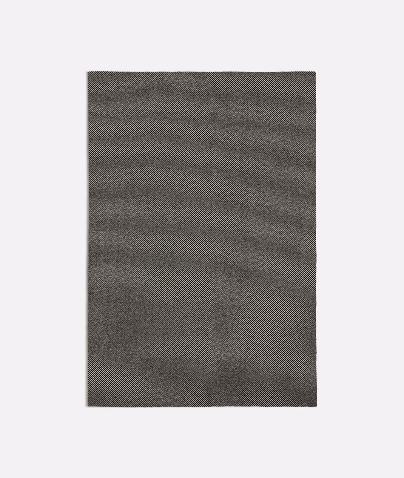 Charcoal grey fabric with a fine peppered diagonal weave and subtly mottled surface