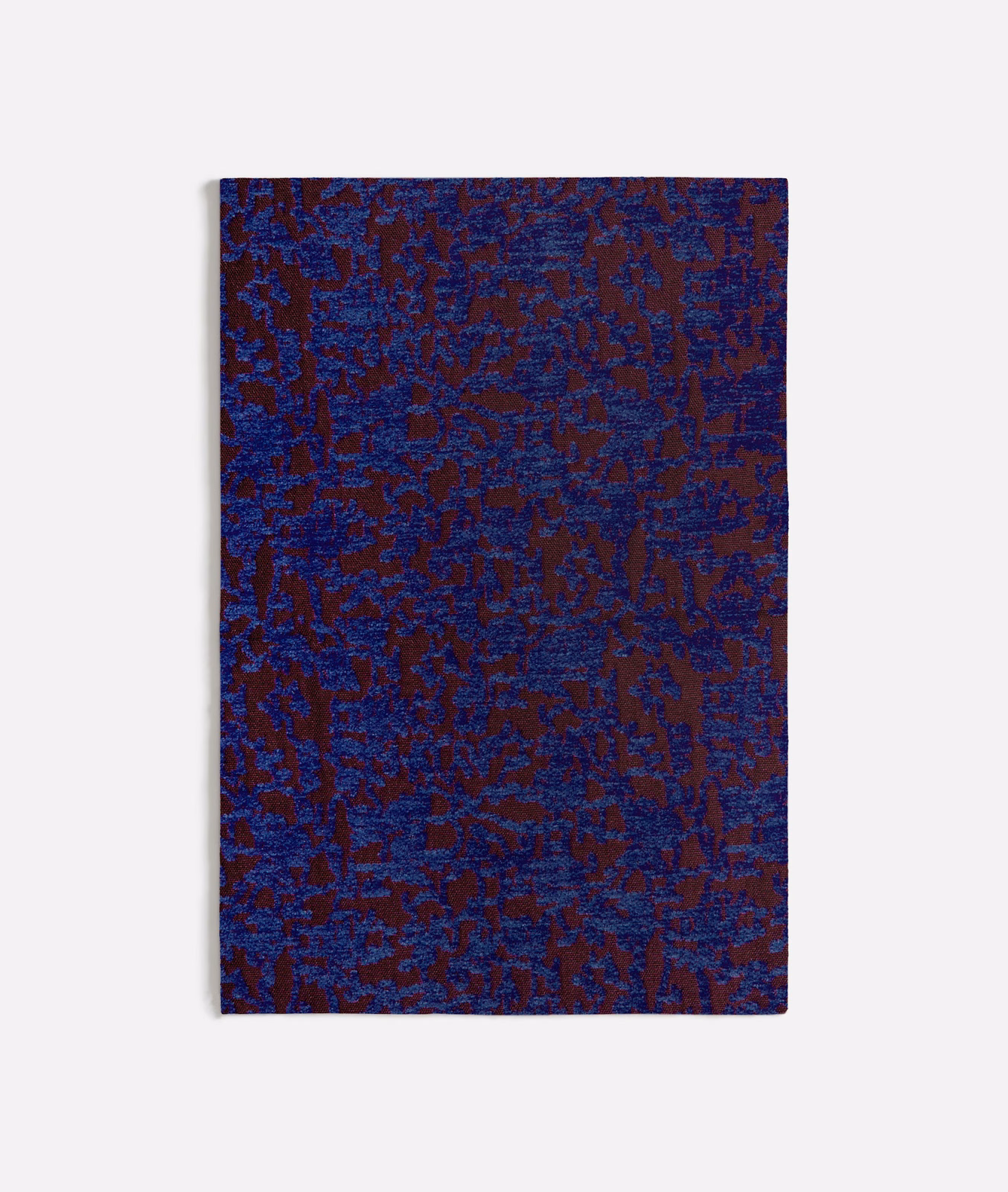 Deep blue-purple woven textile with burgundy organic marks and tactile irregular texture