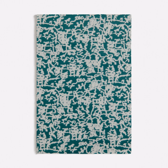 Deep teal textile with dense ivory branching marks and a tactile irregular weave