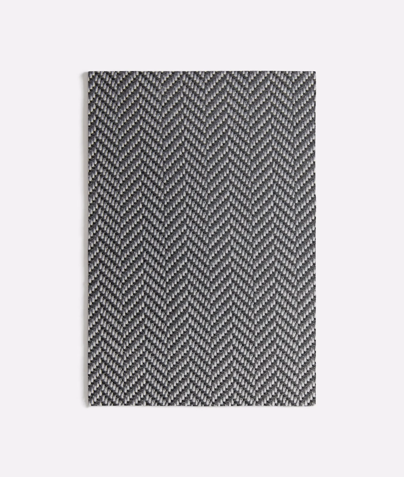 Deep charcoal grey textile showing a fine, tightly packed herringbone weave