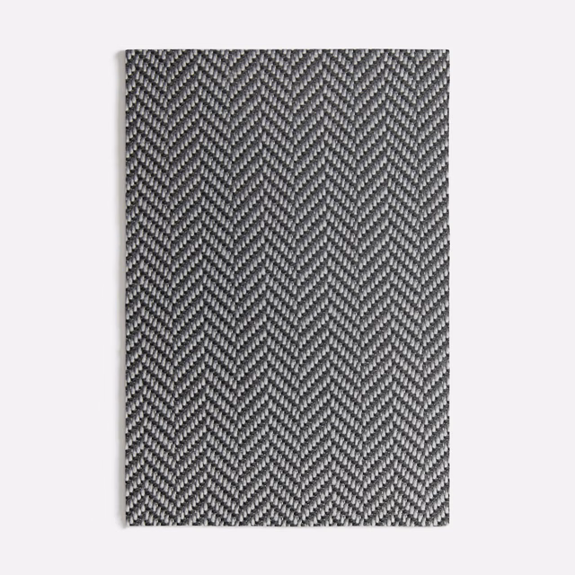 Deep charcoal grey textile showing a fine, tightly packed herringbone weave