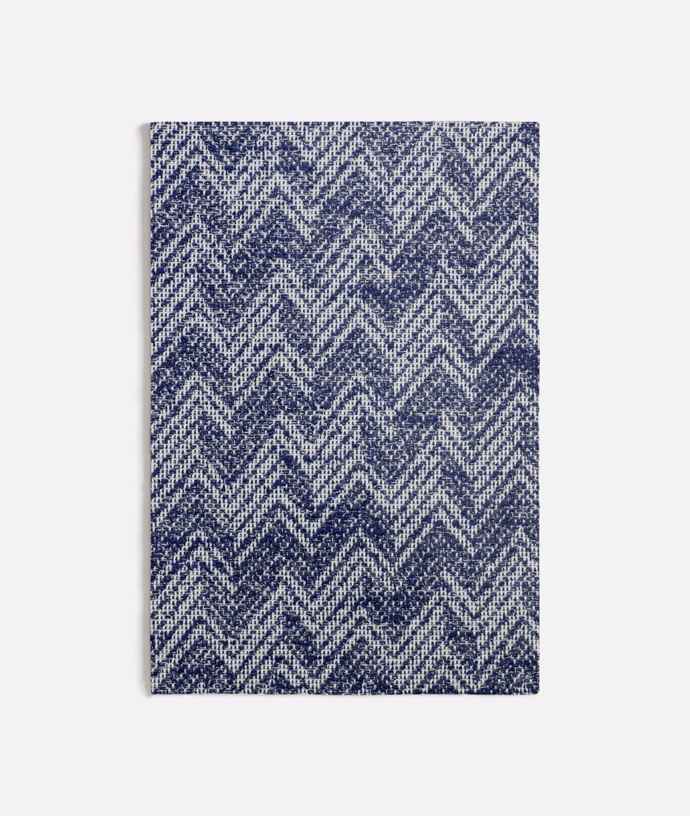 Ink-blue and ivory zigzag chevrons in a closely textured woven surface