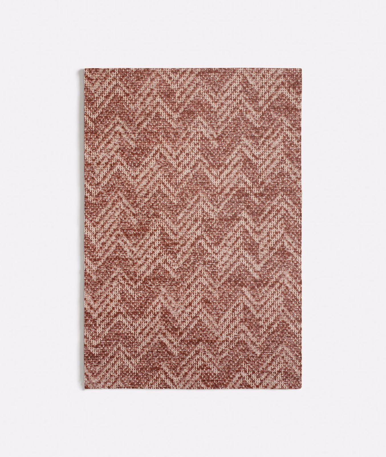 Terracotta woven fabric with pale flecked chevron zigzags and tactile texture