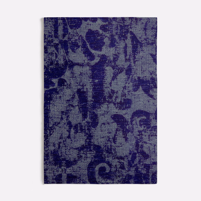 Deep indigo woven fabric with distressed blue-violet abstract botanical marks