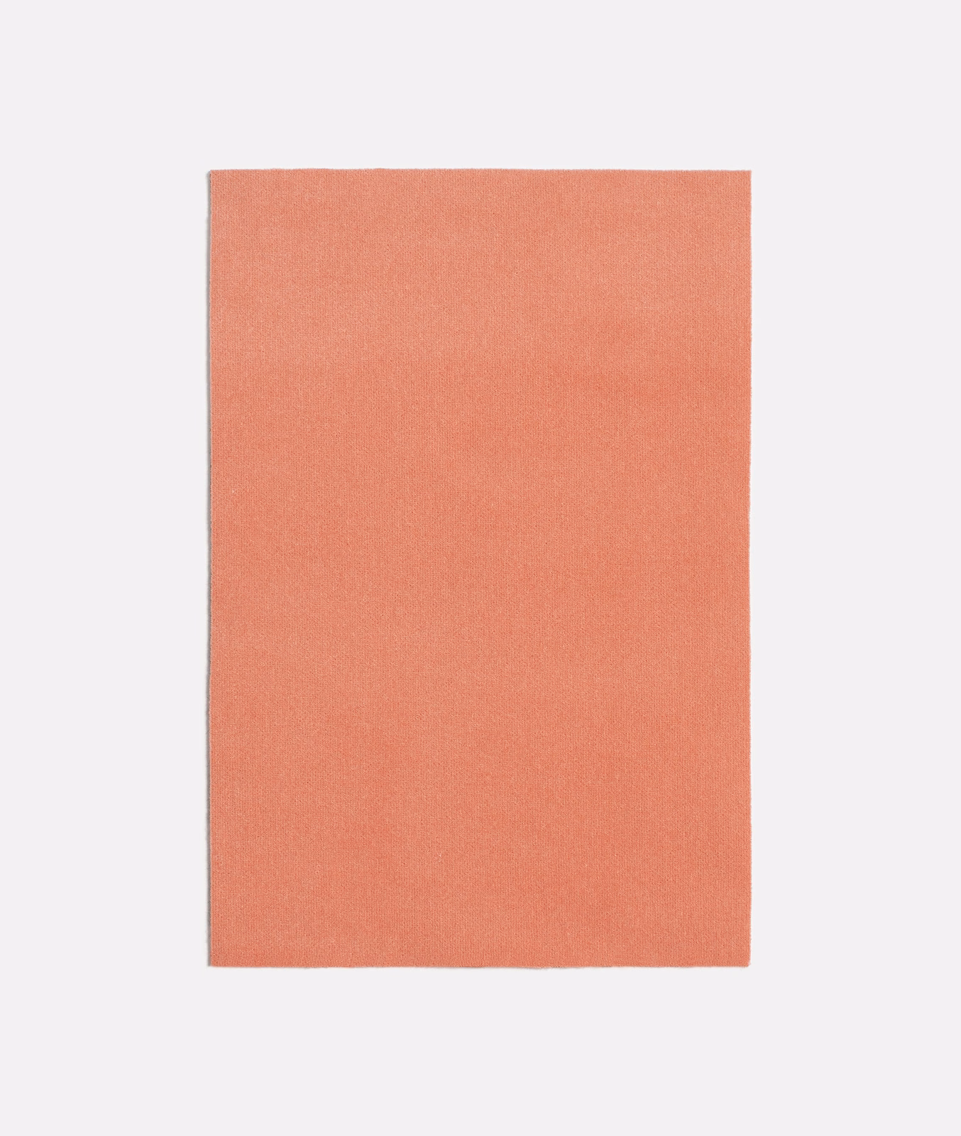 Close view of a plain coral-pink woven textile with a soft, even surface