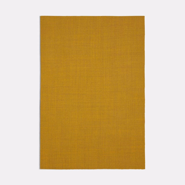Close view of finely woven ochre-gold textile with subtle grid texture