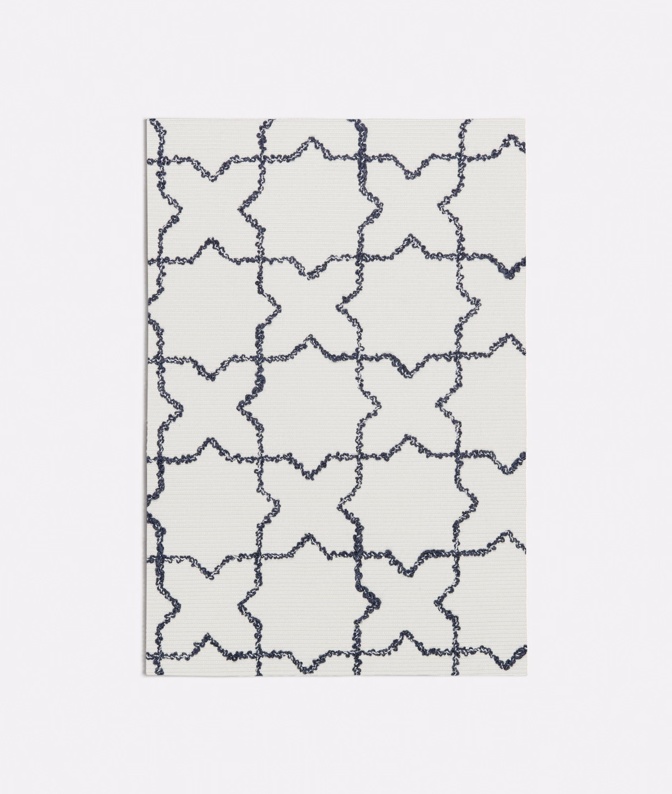 Ivory textile with irregular ink-blue star-and-cross lattice and fine horizontal texture