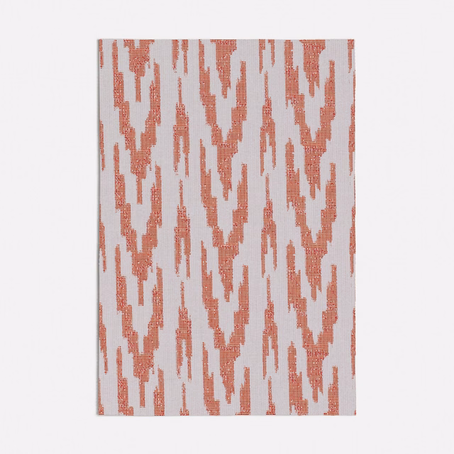 Muted coral-peach ikat motifs on a pale textured woven fabric ground